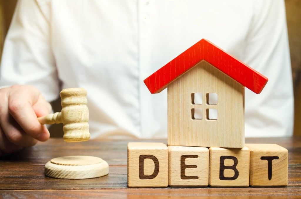 wooden-blocks-with-the-word-debt-and-a-miniature-h-2023-11-27-04-53-41-utc.jpg